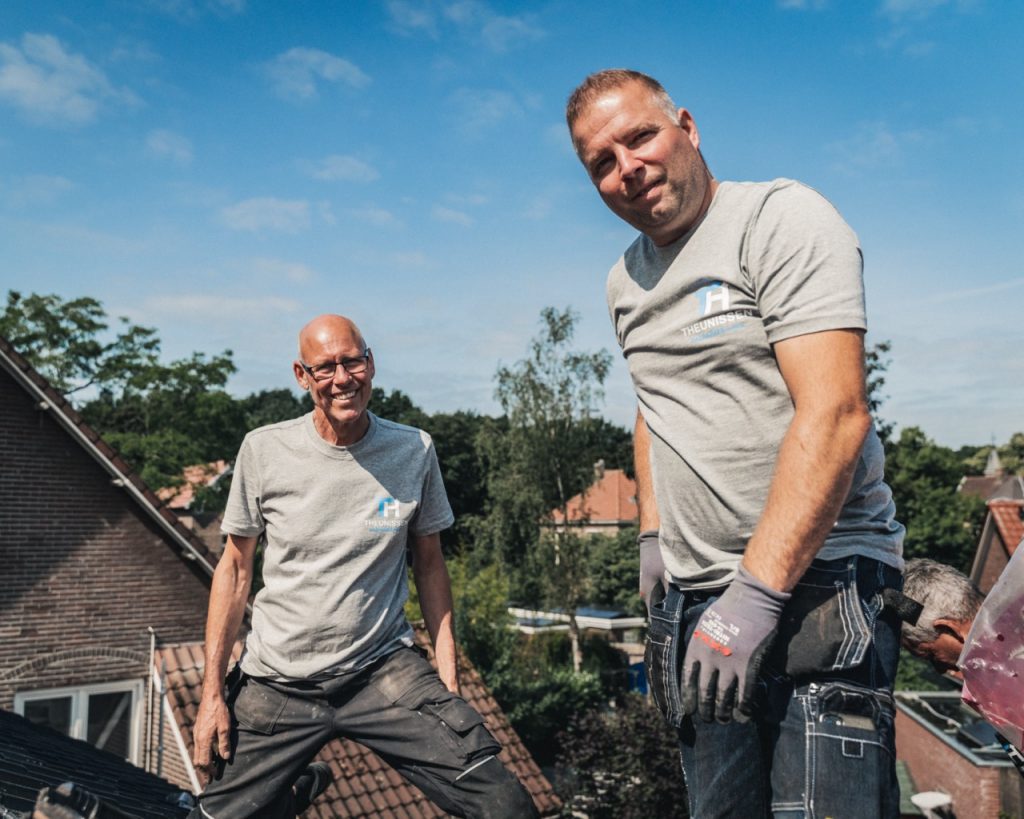 Twee collega's kijken lachend in de camera op het dak
